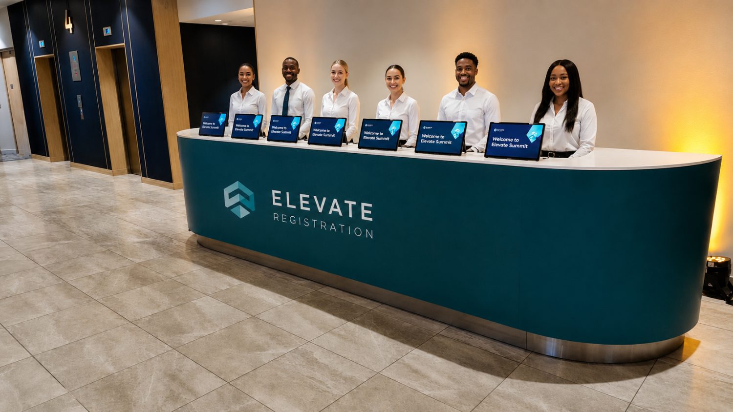GEL staff behind a branded ELEVATE registration desk with laptops, ready to check guests in